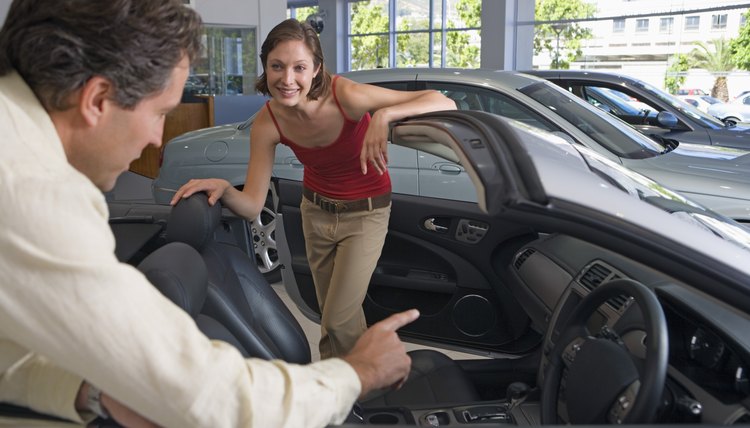 Woman conversing with car salesman