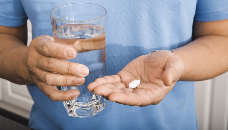 Man Holding Pill and Glass of Water