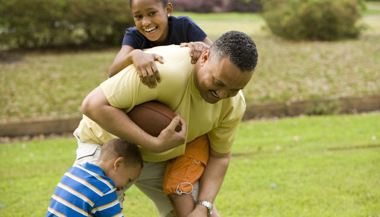 Father playing with their children at park