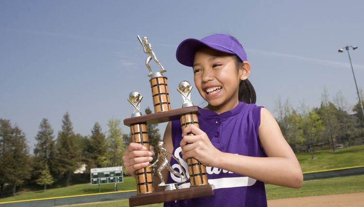 Little league player holding trophy