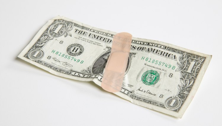 Dollar bill held together by a bandage
