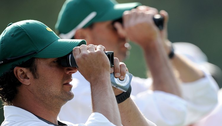 Caddies using rangefinders during a practice round prior to the 2010 Masters.