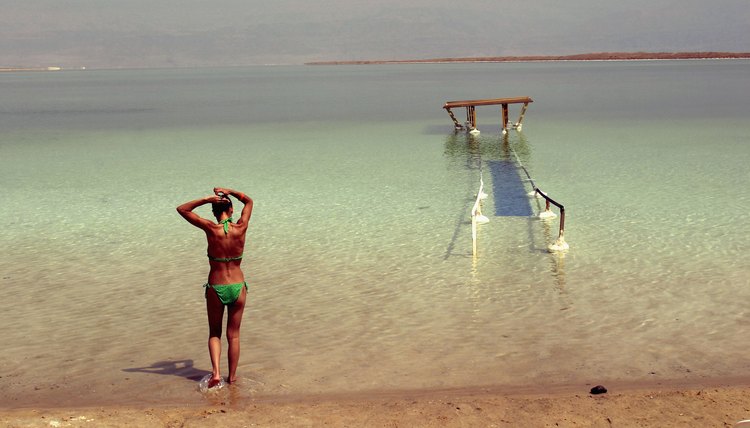 Woman walks toward the Dead Sea for a swim