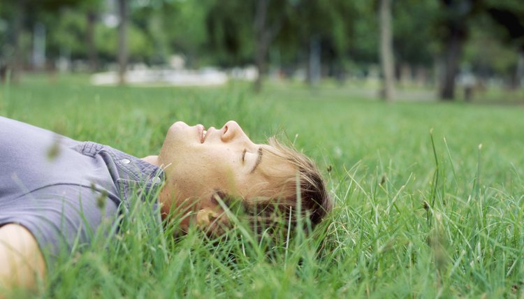 Young man lying on the grass with his eyes closed