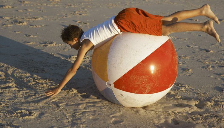 Boy lying on beach ball