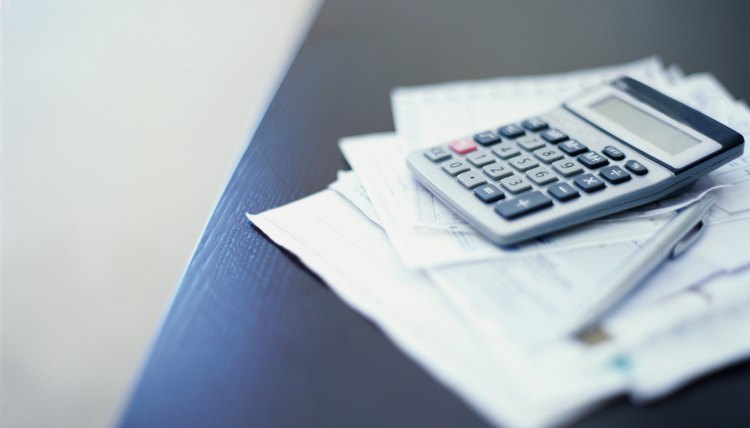 close-up of a calculator and a pen on paper