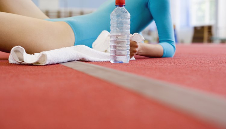 Young gymnast resting with bottled water