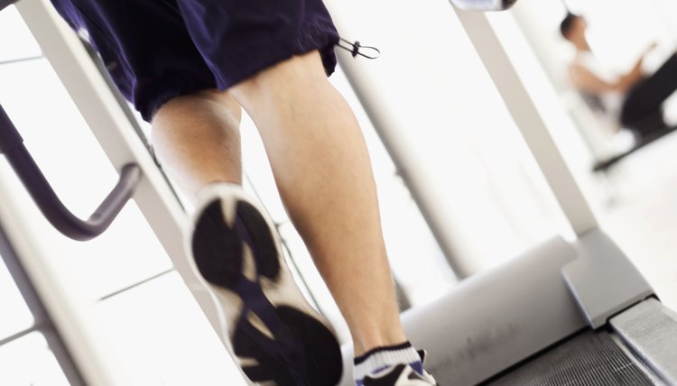 Close-up of the legs of a young man on a treadmill