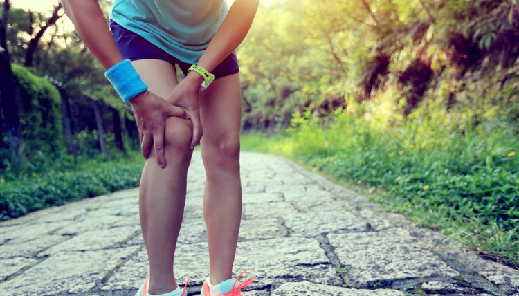 woman runner hold her sports injured knee