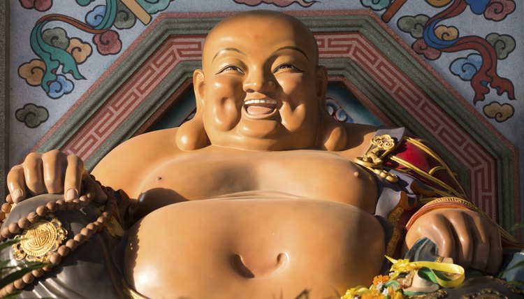 A statue of a colorful, happy Buddha.