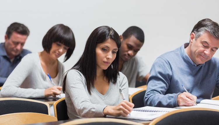 Business students taking notes during lecture.