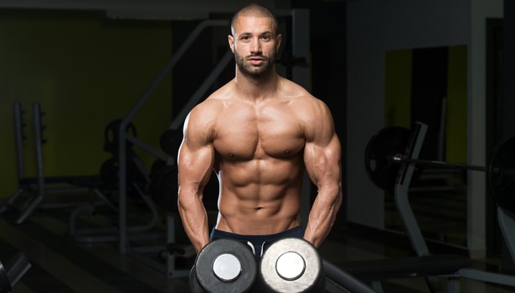 Bodybuilder Exercising Shoulders With Dumbbells