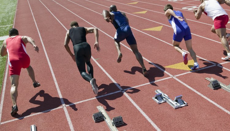 Male sprinters leaving starting blocks