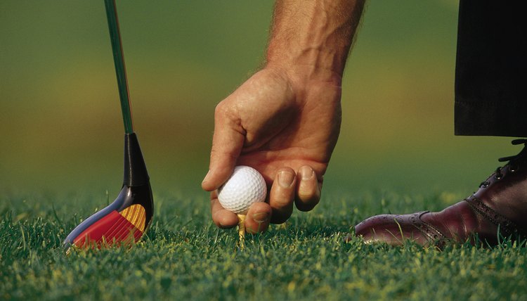 Golfer placing ball on tee