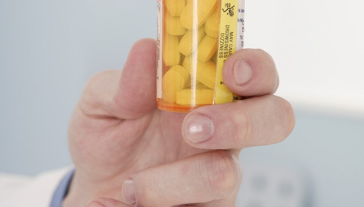 Close-up of a man holding a prescription pill bottle