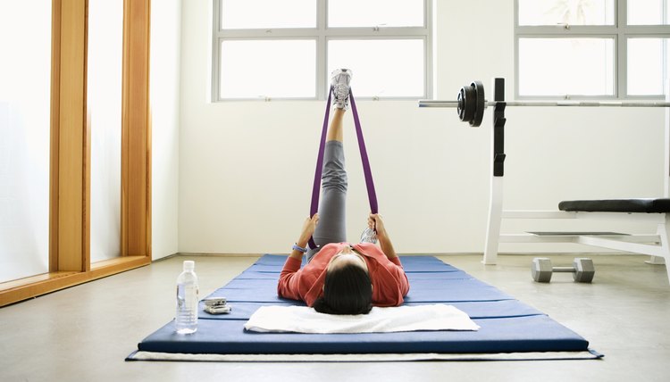 Woman doing stretching exercises on mat in gym