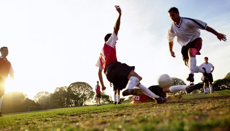Soccer players tackling for ball, ground view