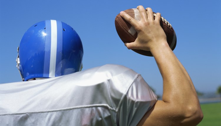 rear view of a football player throwing a football