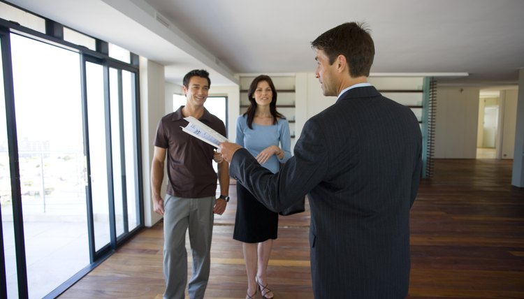 Asesor inmobiliario muestra una vivienda a una pareja.
