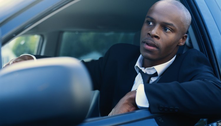 Businessman sitting in car looking out of window