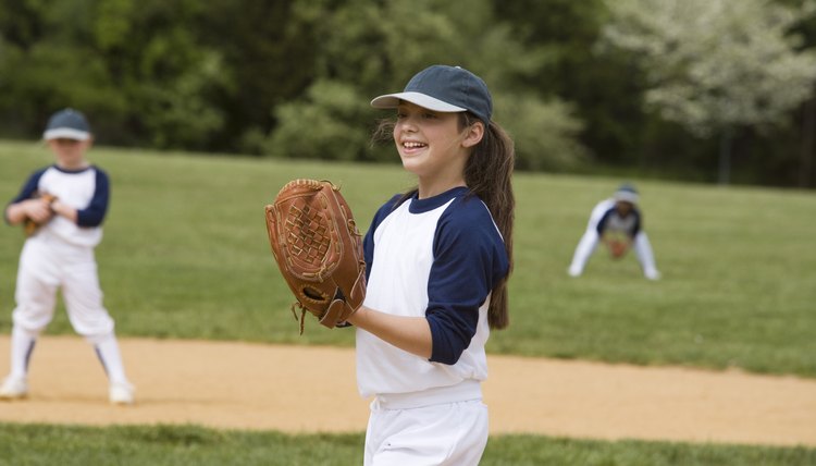 Girl pitching in little league softball game