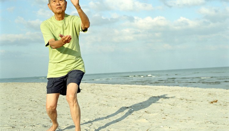 Senior man practicing tai chi on beach