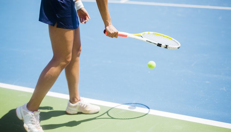 Beautiful female tennis player serving