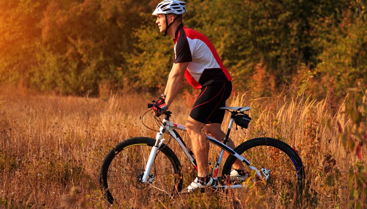 cyclist man cycling on a rural road during sunset