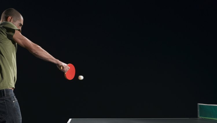 Young man hitting backhand in table tennis game