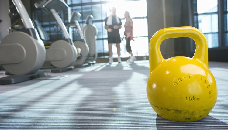 Yellow medicine ball on floor in health club with couple