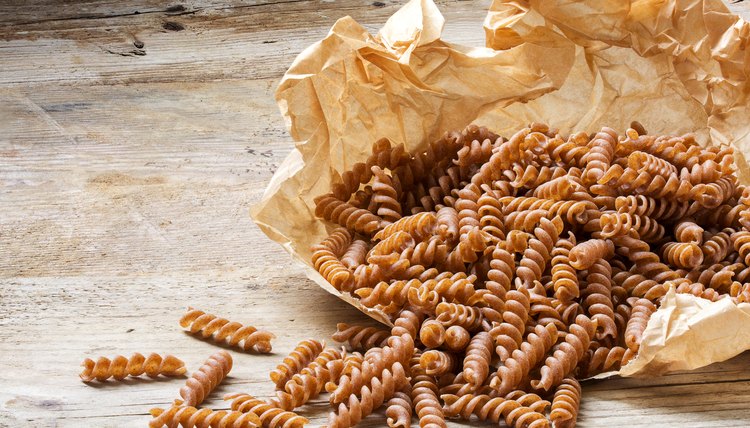 wholemeal pasta fusilli from organic whole grain spelt on paper