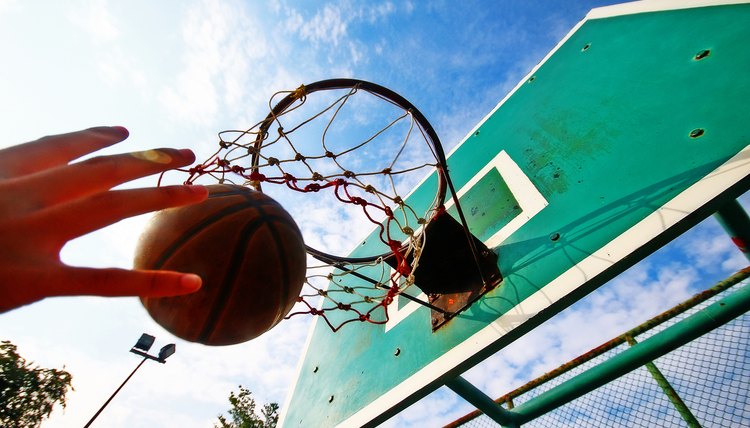 Basketball thrown in the hoop, scoring in game.