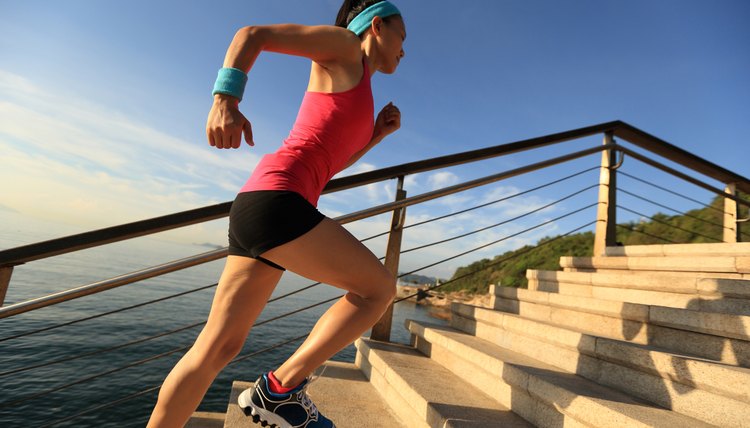 healthy lifestyle sports woman running up on stone stairs seaside