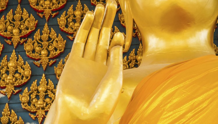 A close-up of a Buddha statue's hand gesture.