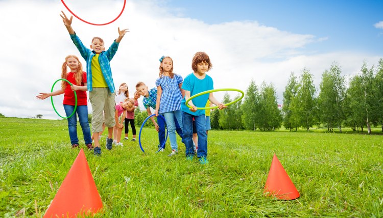 Happy children throw colorful hoops on cones