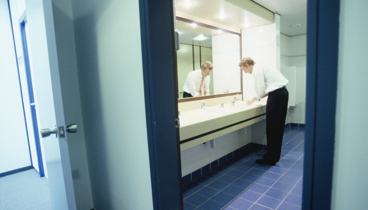 Businessman washing hands in bathroom