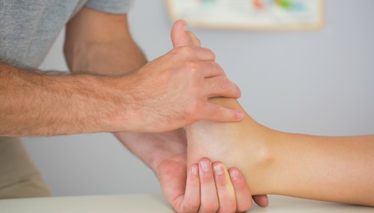 Physiotherapist controlling patients foot