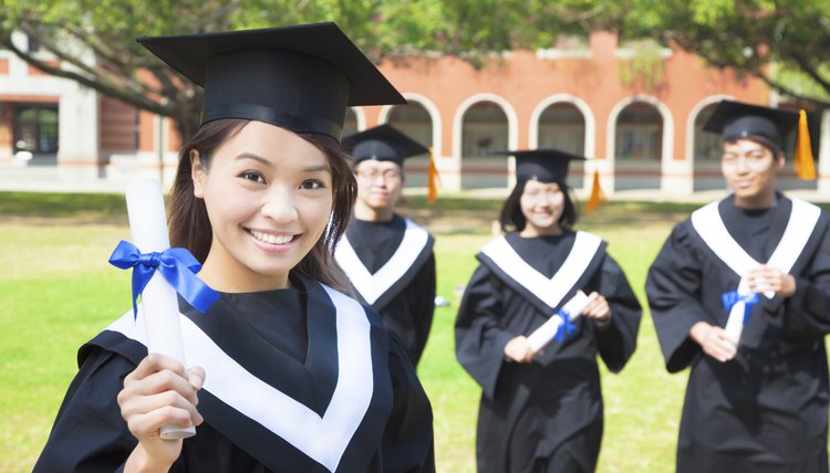 Young graduate holding degree on graduation day