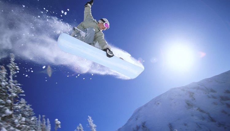 Low Angle Mid Air Shot of a Woman Snowboarding