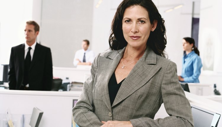 Portrait of a Serious Businesswoman, in an Open Plan Office, with Colleagues in the Background