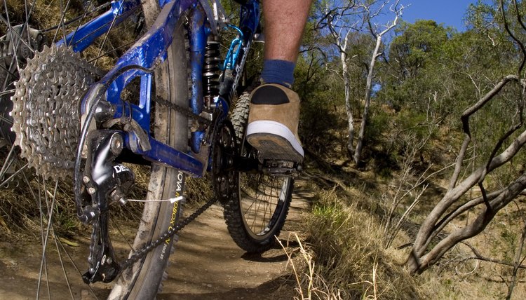 A stock photograph of an active young man riging through the country on a mountain bike.