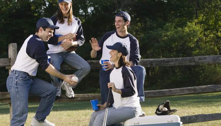 Friends in sport uniforms chatting over drinks