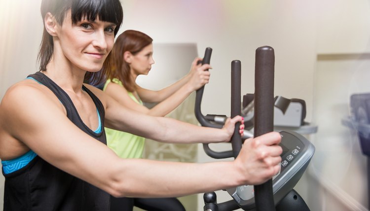 Two fit women on a cross trainer