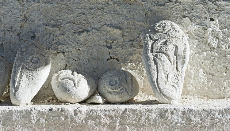 Stones carved with mantras on background of roughly plastered wall of temple in Tibet.