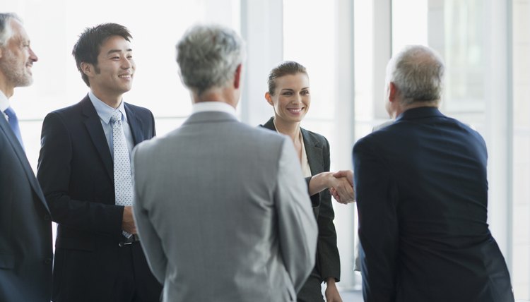 Business people shaking hands in conference room