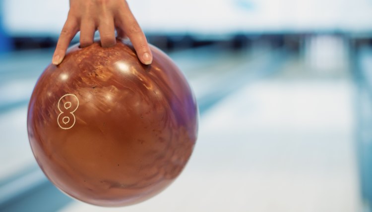 Woman's hand throwing ball in bowling club.