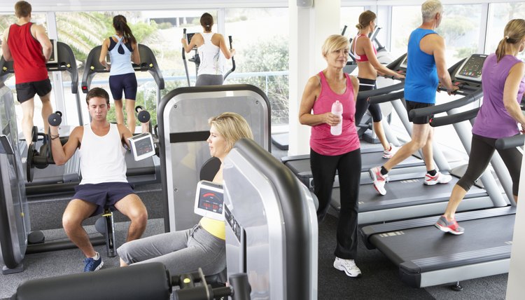 Elevated View Of Busy Gym With People Exercising On Machines