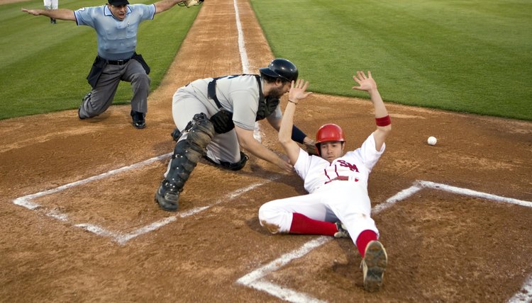 USA, California, San Bernardino, baseball runner sliding safely into home base