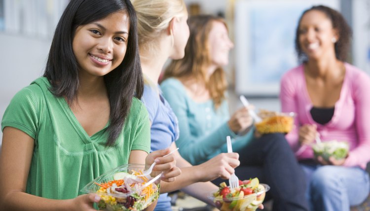Teenage girls eating lunch off-campus