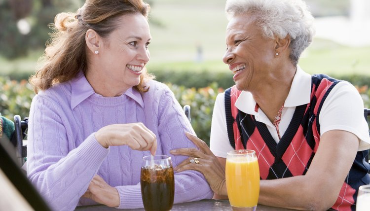 Two Female Friends Enjoying Beverage By A Golf Course